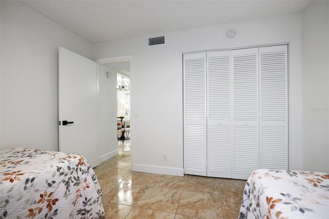 6291 Bahia Del Mar Cir Unit 103, Saint Petersburg, FL 33715 - bedroom with visible vents, baseboards, an inviting chandelier, marble finish floor, and a closet