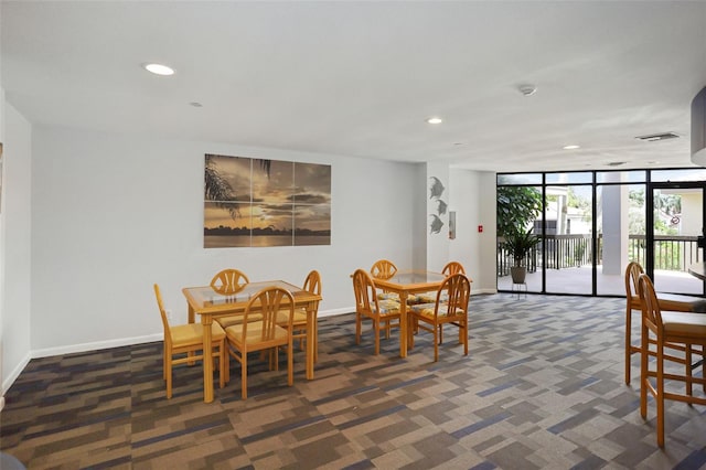 dining space featuring dark carpet and expansive windows