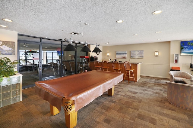 rec room with a textured ceiling, billiards, bar area, and carpet floors