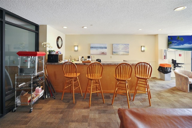 bar featuring a textured ceiling and carpet flooring