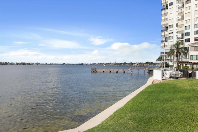 view of dock featuring a water view and a yard