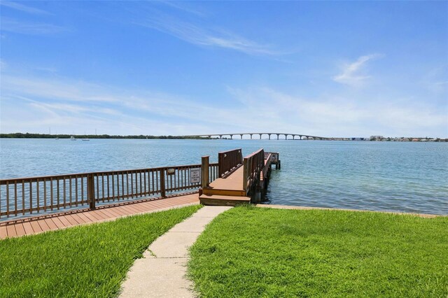 dock area with a water view and a lawn