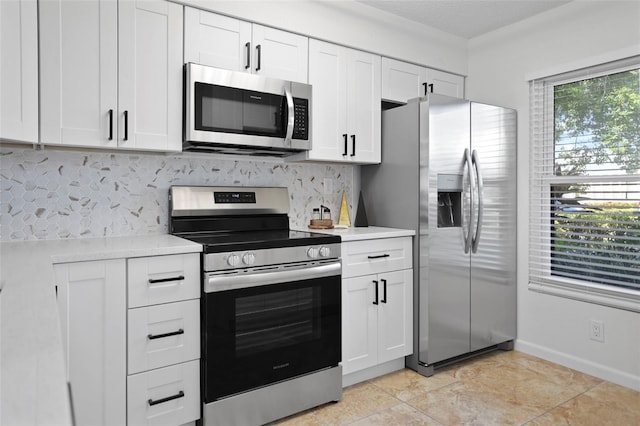 6291 Bahia Del Mar Cir Unit 103, Saint Petersburg, FL 33715 - kitchen featuring decorative backsplash, white cabinetry, stainless steel appliances, and light countertops
