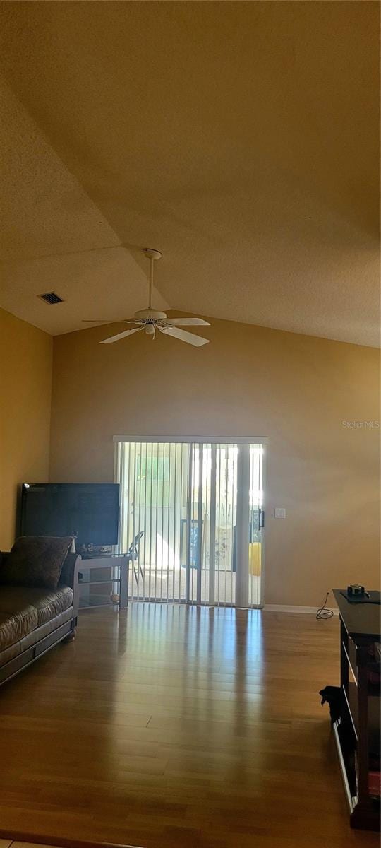 interior space featuring vaulted ceiling, ceiling fan, hardwood / wood-style flooring, and a textured ceiling