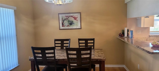 dining space with wood-type flooring and a chandelier