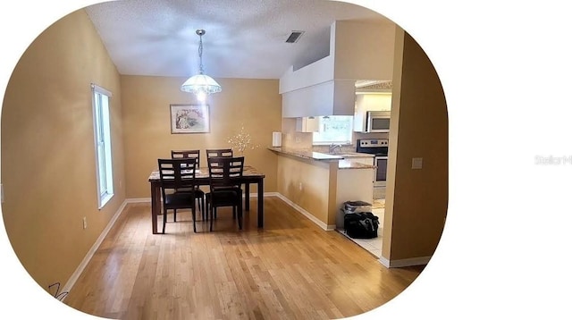 4432 Whitton Way, New Port Richey, FL 34653 - dining space featuring light wood-type flooring and arched walkways