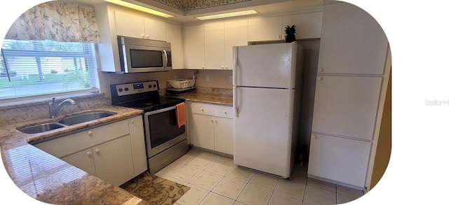 4432 Whitton Way, New Port Richey, FL 34653 - kitchen with stainless steel appliances, light tile patterned floors, white cabinets, and light stone counters