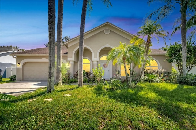 mediterranean / spanish house with a lawn and a garage