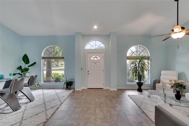 tiled foyer featuring ceiling fan