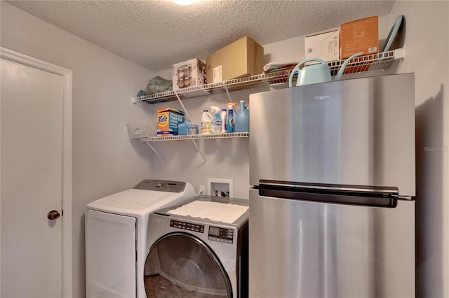 washroom with a textured ceiling and independent washer and dryer