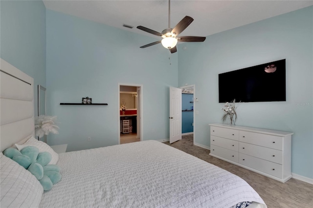 bedroom featuring a high ceiling, carpet flooring, ceiling fan, and ensuite bathroom