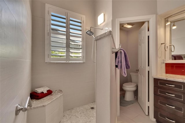 bathroom with walk in shower, vanity, toilet, and tile patterned floors