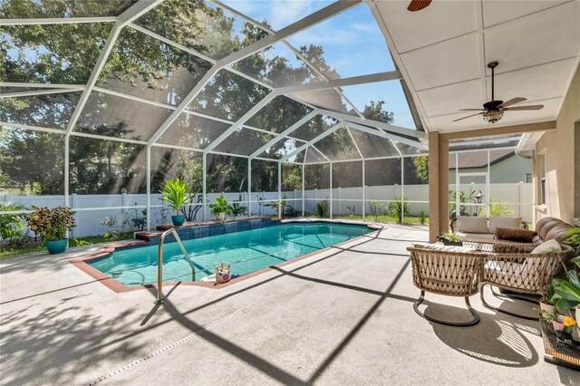 view of swimming pool with a lanai, ceiling fan, and a patio area