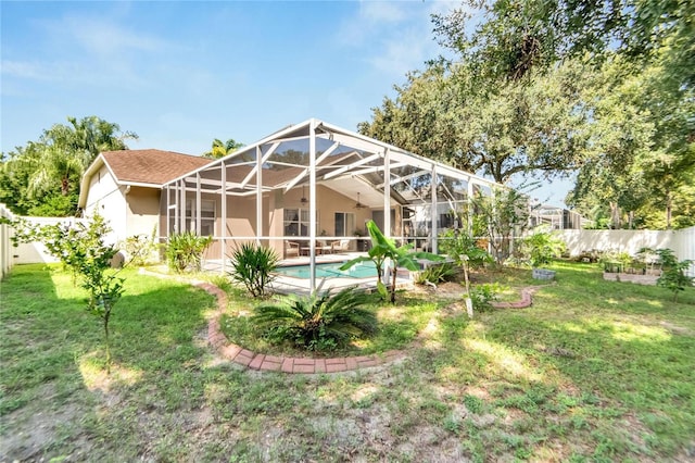 rear view of property with a fenced in pool, glass enclosure, a patio area, and a lawn