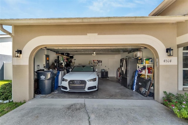 garage with stainless steel refrigerator and electric panel