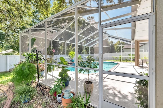 view of pool with glass enclosure and a patio