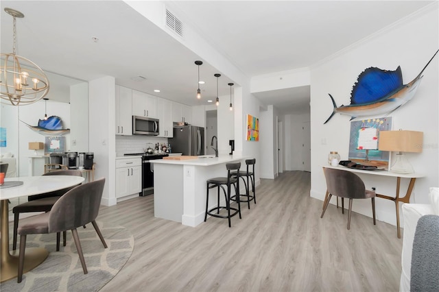 kitchen with light hardwood / wood-style flooring, stainless steel appliances, a breakfast bar, and white cabinetry