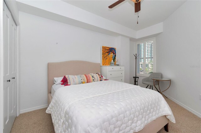 bedroom with light carpet, a closet, and ceiling fan