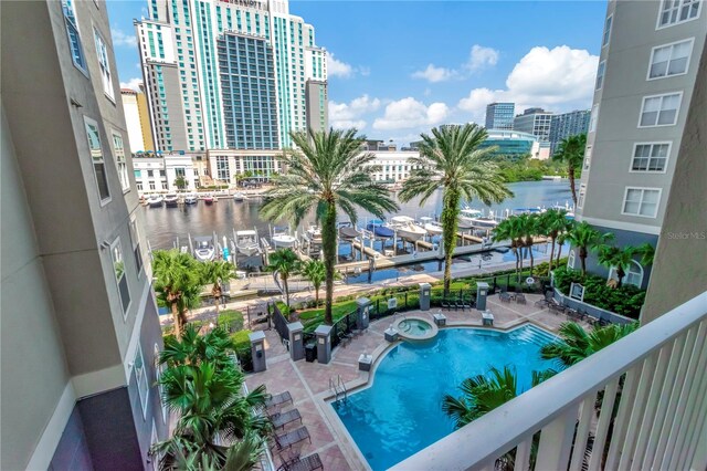 view of pool featuring a patio and a water view