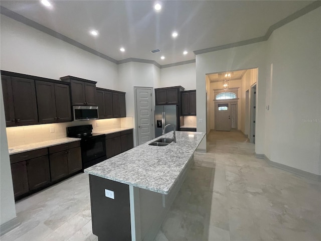 kitchen featuring sink, backsplash, a center island with sink, crown molding, and appliances with stainless steel finishes