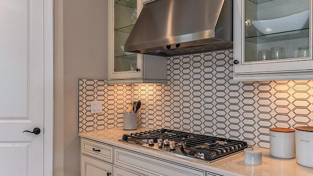 kitchen featuring wall chimney range hood, backsplash, and stainless steel gas cooktop