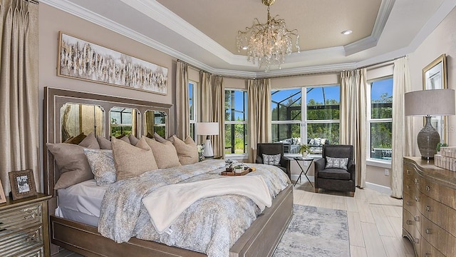 bedroom featuring ornamental molding, a notable chandelier, and a tray ceiling