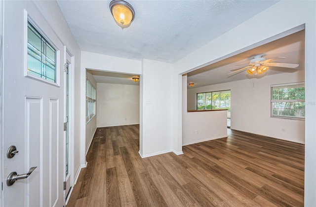 interior space featuring ceiling fan, a textured ceiling, and dark hardwood / wood-style flooring