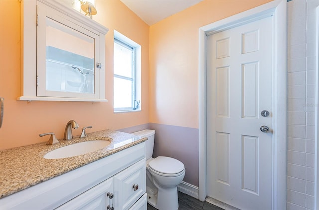 bathroom featuring walk in shower, vanity, and toilet