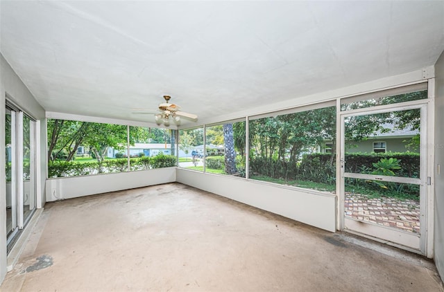 unfurnished sunroom featuring ceiling fan and a wealth of natural light