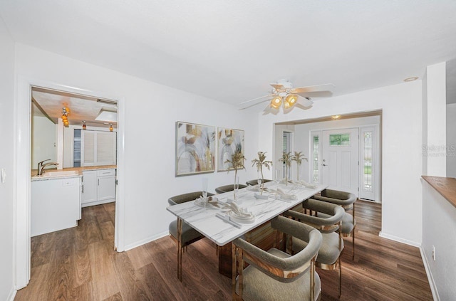 dining area with ceiling fan, dark hardwood / wood-style floors, and sink