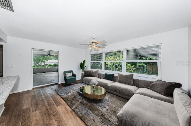 living room featuring ceiling fan and dark hardwood / wood-style floors