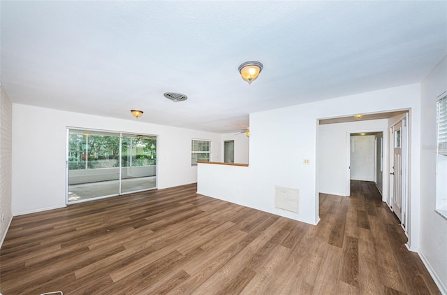 unfurnished living room with ceiling fan and dark wood-type flooring