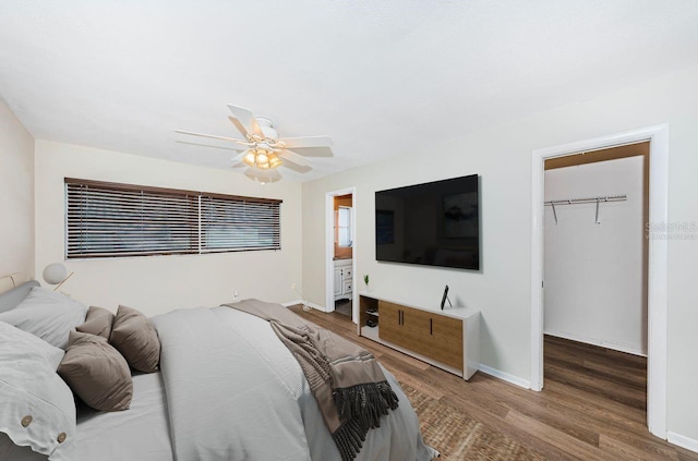 bedroom featuring wood-type flooring, a spacious closet, ceiling fan, and a closet