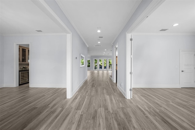 hallway with ornamental molding and light hardwood / wood-style floors