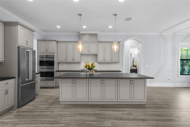 kitchen with a kitchen island, pendant lighting, gray cabinetry, ornamental molding, and stainless steel appliances