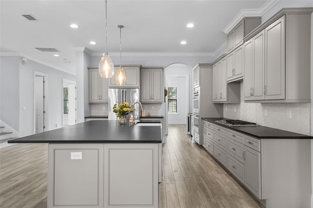 kitchen featuring pendant lighting, appliances with stainless steel finishes, gray cabinets, and sink