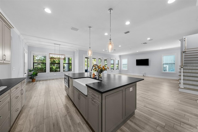 kitchen featuring a kitchen island with sink, sink, gray cabinets, and plenty of natural light