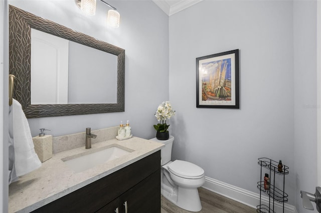 bathroom with hardwood / wood-style flooring, vanity, toilet, and crown molding