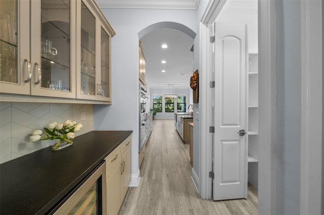 bar featuring sink, crown molding, backsplash, wine cooler, and light hardwood / wood-style floors