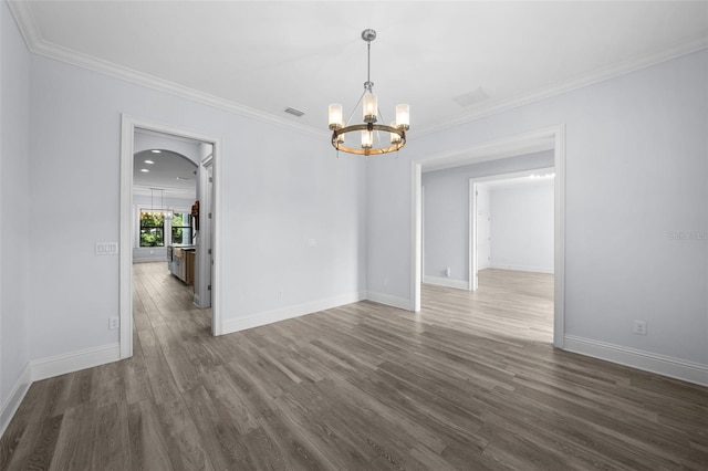 unfurnished room with crown molding, dark hardwood / wood-style floors, and a chandelier