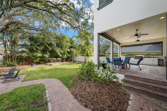 view of yard featuring ceiling fan and a patio area