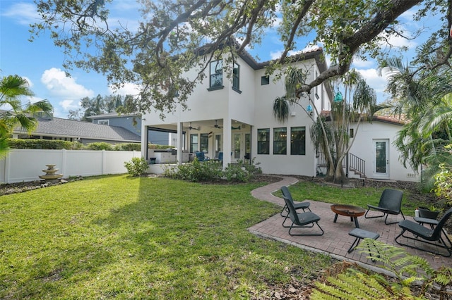 back of house featuring a yard, a fire pit, a patio, and ceiling fan