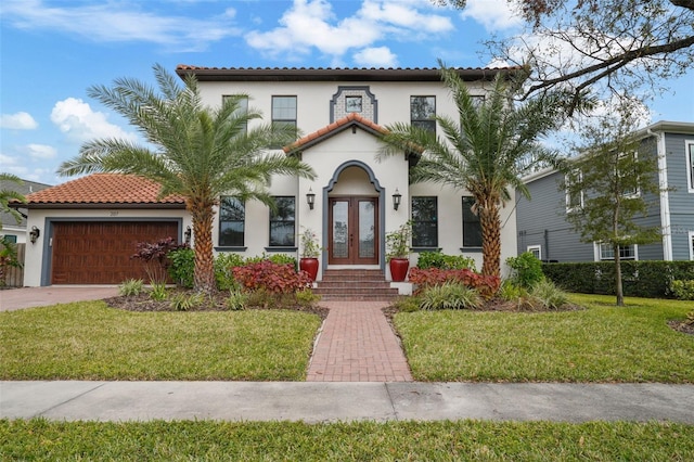 mediterranean / spanish home with french doors, a garage, and a front lawn