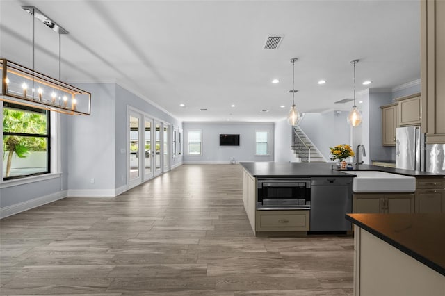 kitchen with hanging light fixtures, ornamental molding, appliances with stainless steel finishes, and light hardwood / wood-style floors