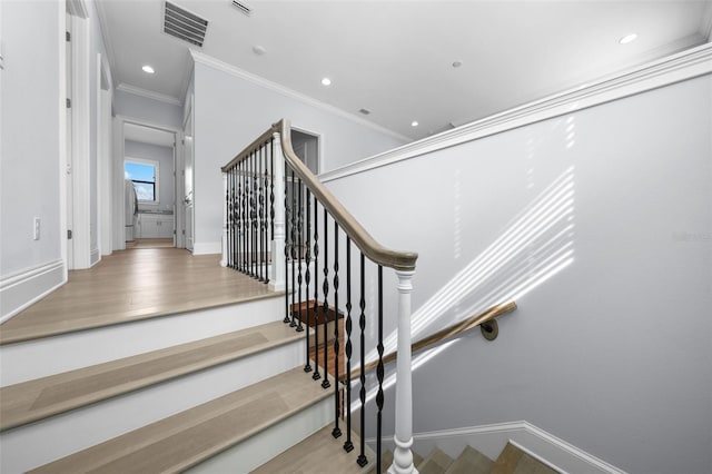 stairway with hardwood / wood-style flooring and ornamental molding