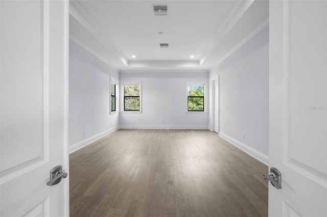 unfurnished room with crown molding, dark wood-type flooring, and a tray ceiling