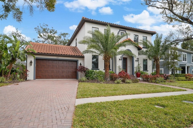 mediterranean / spanish home with a garage and a front yard