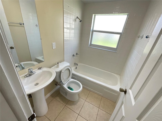 bathroom featuring tile patterned flooring, tiled shower / bath combo, and toilet