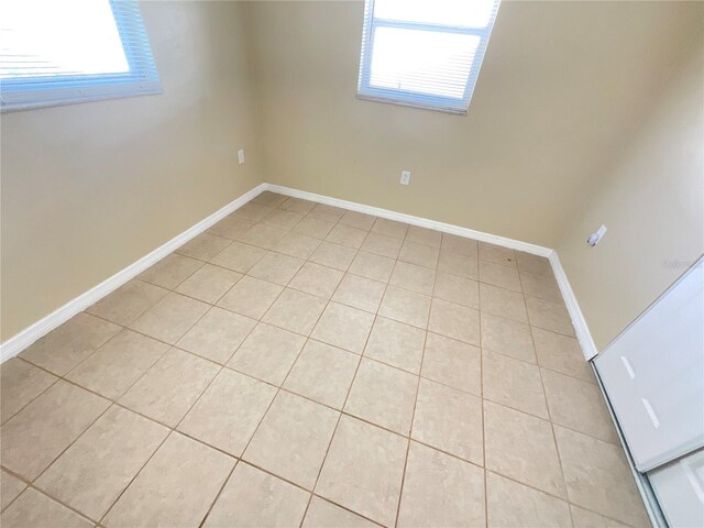 tiled spare room with a healthy amount of sunlight