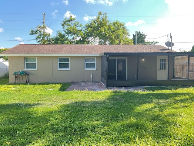 rear view of house with a sunroom and a yard